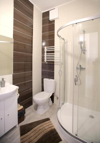 a bathroom with a toilet and a sink and a shower at Kompleks Perła in Łomża