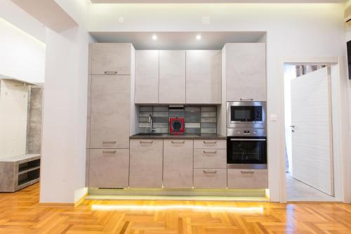 a kitchen with white cabinets and a red appliance at Villa Domina in Split