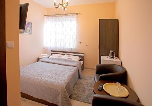 a small bedroom with a bed and a chair at Kompleks Perła in Łomża