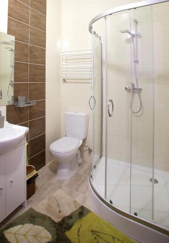 a bathroom with a toilet and a glass shower at Kompleks Perła in Łomża