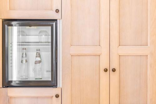 a glass refrigerator with bottles inside of it at Relais Paradiso Resort & Spa in Gualdo Cattaneo
