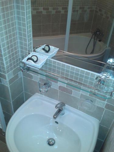 a bathroom with a sink and a mirror and a shower at Hotel pizzeria Belmonte in Špindlerův Mlýn