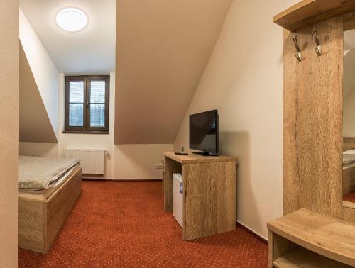 a bedroom with a bed and a television on a cabinet at Panský mlýn in Opava
