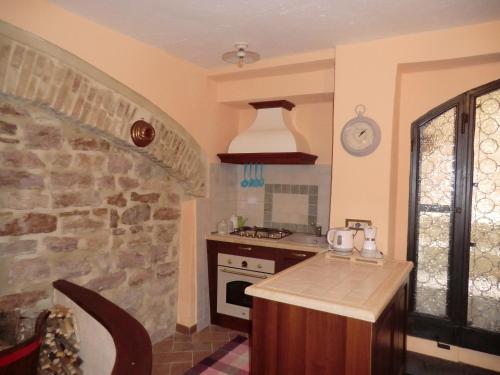 a kitchen with a stove and a stone wall at Residenza Frenguelli in Spello