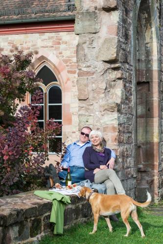a man and woman sitting on a table with a dog at Kloster Hornbach in Hornbach
