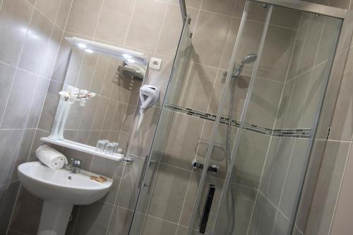 a bathroom with a shower and a sink at Hotel Paganini in Nice