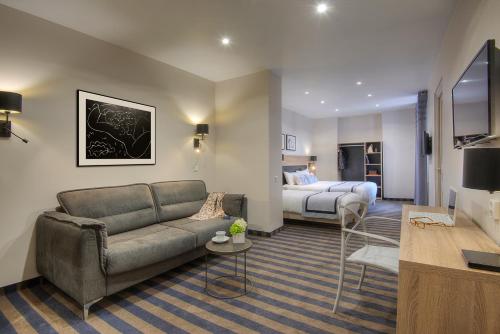 a living room with a couch and a bed at Hotel Paganini in Nice