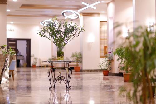 a table with a vase of flowers on top of it at Tolip Family Park Hotel in Cairo