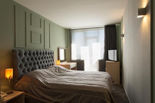 a bedroom with a large bed and a window at Romantique Veles Hotel in Veles