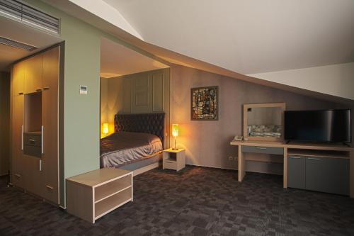 a hotel room with a bed and a television at Romantique Veles Hotel in Veles