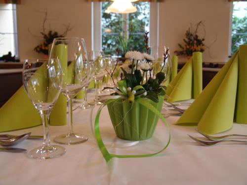 a table with wine glasses and a vase of flowers at Gasthaus & Weingut zum Stern in Sulzfeld am Main