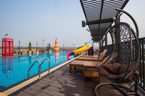 a pool with a slide and chairs next to a playground at B-your home Hotel Don Mueang Airport Bangkok 如你家酒店 in Bangkok