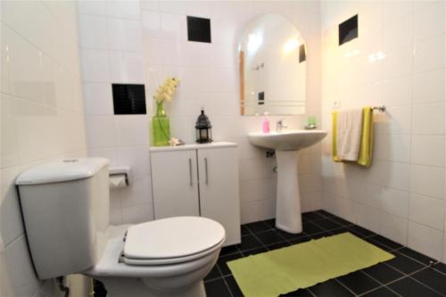 Baño blanco con aseo y lavamanos en Apartamento Orquidea, en Funchal