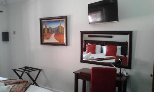 a room with two beds and a mirror at Amani Guest Lodge in Port Elizabeth