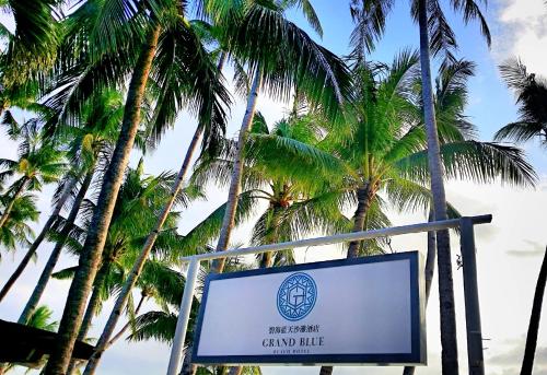 a sign in front of some palm trees at Grand Blue Beach Hotel in Boracay