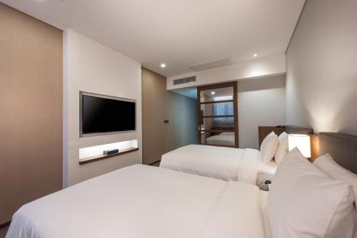 a hotel room with two beds and a flat screen tv at ENA Suite Hotel Namdaemun in Seoul