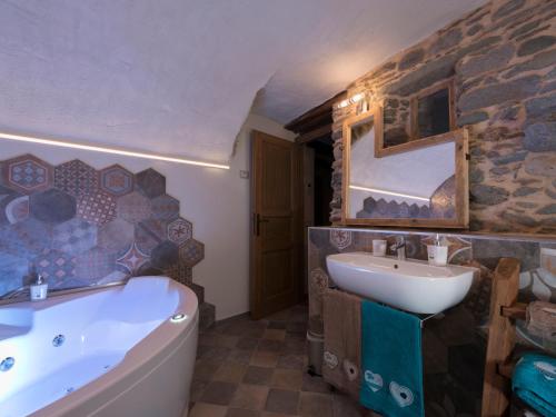 a bathroom with a tub and a sink at Chambres d'hôtes La Moraine Enchantée in Aosta