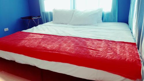 a bed with a red and white blanket on it at Miss Leila in San Andrés