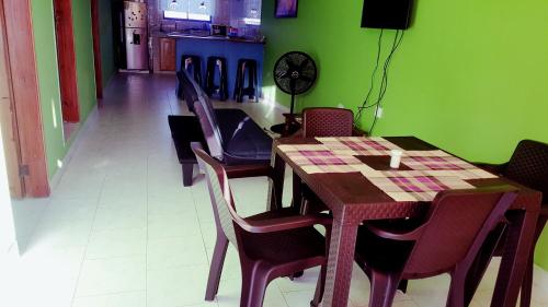 a dining room with a wooden table and chairs at Miss Leila in San Andrés