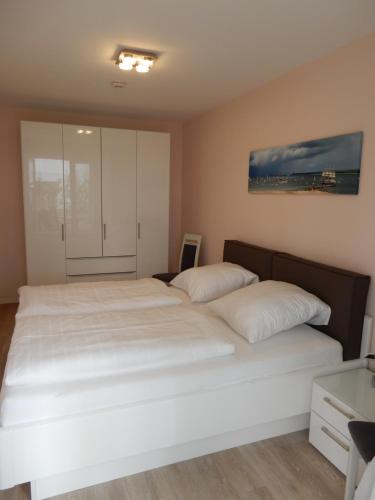 een slaapkamer met 2 bedden en witte kussens bij Ferienwohnung Timmendorfer in Timmendorfer Strand