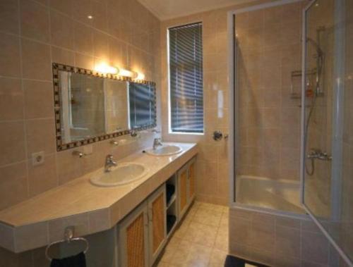 a bathroom with two sinks and a shower at Chala-Kigi Apartments in Swakopmund