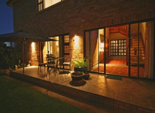 a patio with a table and an umbrella at Chala-Kigi Apartments in Swakopmund