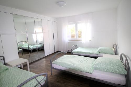 Habitación hospitalaria con 2 camas y espejo en Work & Stay Sankt Augustin en Sankt Augustin