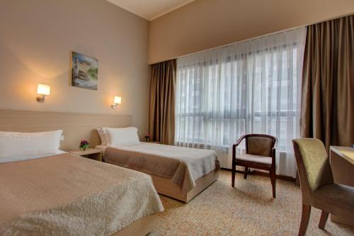 Habitación de hotel con 2 camas y ventana en Bishkek Boutique Hotel en Bishkek