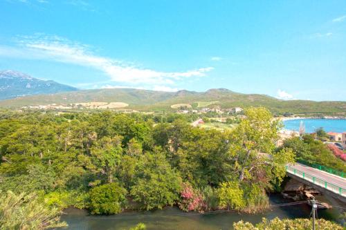 a view of a river with a bridge and mountains at Hotel Macchia e Mare in Pietracorbara