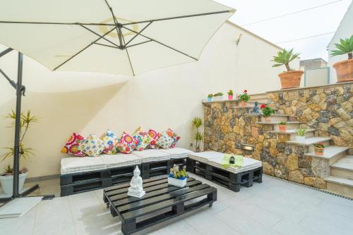 a living room with a couch and a stone wall at Casa Holganza in Maria de la Salut