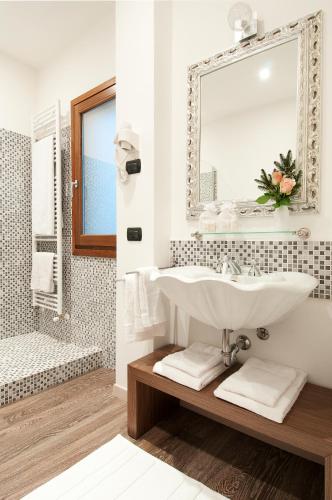 a white bathroom with a sink and a mirror at Bed&Garden in Cesate