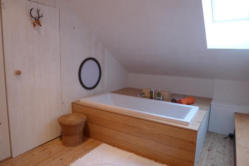 a bathroom with a large white tub and a mirror at Beautiful and Spacious Contemporary house in Oignies