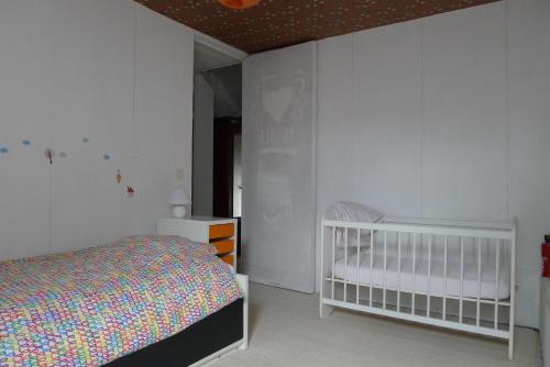 a bedroom with a bed and a crib in it at Beautiful and Spacious Contemporary house in Oignies-en-Thierache