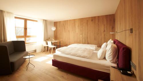 a bedroom with a bed and a chair and a table at Landhotel Weißes Roß in Illschwang