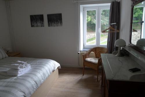 a bedroom with a bed and a desk and a window at Beautiful and Spacious Contemporary house in Oignies-en-Thierache