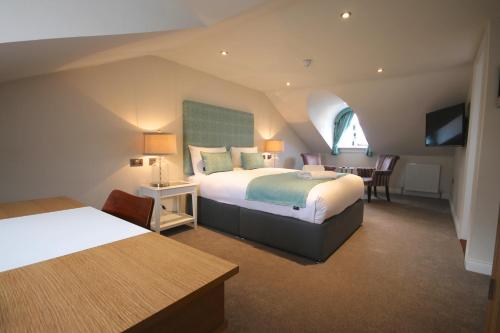 a hotel room with two beds and a table at Andover House Hotel & Restaurant - Adults only in Great Yarmouth