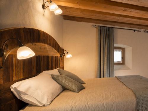 a bedroom with a large bed with a wooden headboard at Chambres d'hôtes La Moraine Enchantée in Aosta