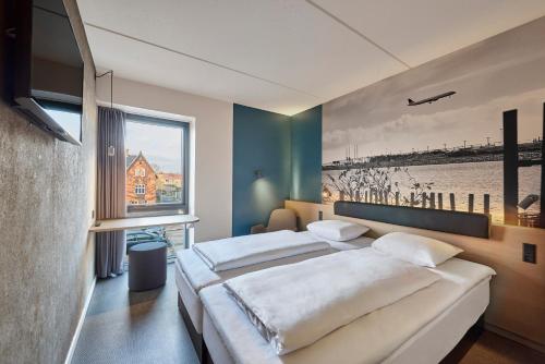 a bedroom with two beds and a large window at Zleep Hotel Copenhagen Airport in Copenhagen