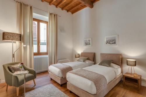 フィレンツェにあるApartments Florence - Luna Chicのベッドルーム1室(ベッド2台、椅子、窓付)