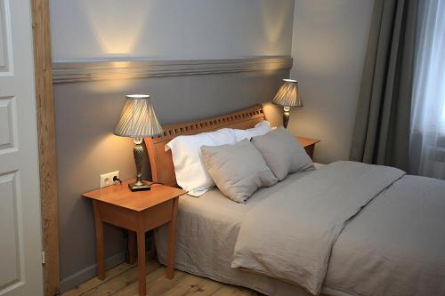 a bedroom with a bed and a table with two lamps at Meke in Mustkalni