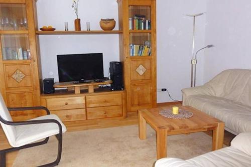 a living room with a couch and a tv at Haus Harmonie in Bad Driburg