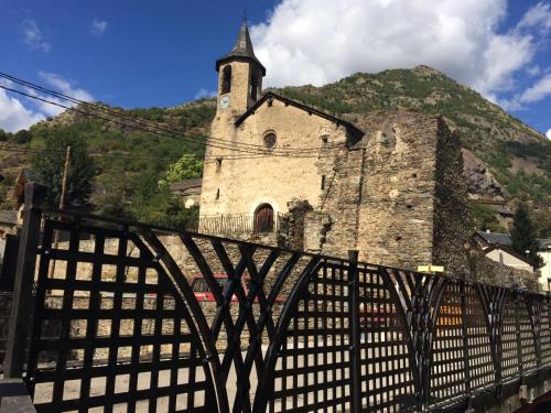 an old building with a clock tower on a mountain at Hotel Estanys Blaus in Tavascan