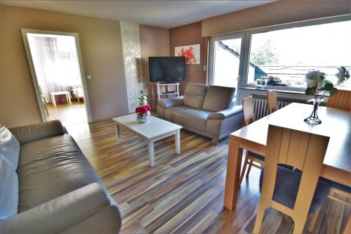 een woonkamer met een bank en een tafel bij Work & Stay Sankt Augustin mit Dachterasse in Sankt Augustin
