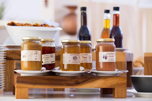 four jars of honey on a tray with bottles of wine at Akoya Hotel & Spa in Saint-Gilles les Bains