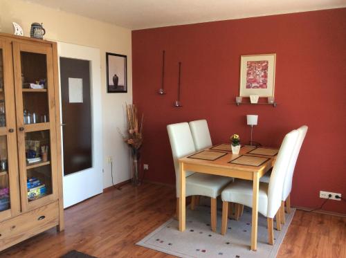 a dining room with a wooden table and white chairs at Apartment Panorama in Sonthofen