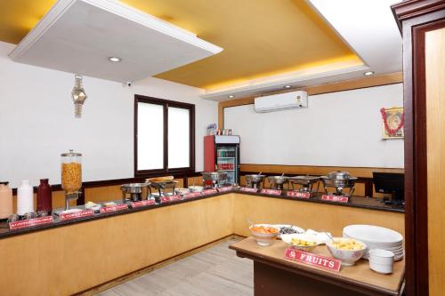 a restaurant kitchen with a counter with food at Sri Aarvee Hotels in Coimbatore