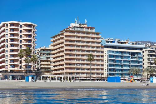 twee hoge gebouwen naast het strand en de oceaan bij Apartamentos La Jabega in Fuengirola