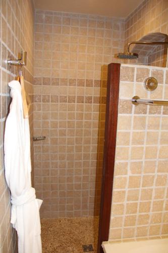 a bathroom with a shower with a white towel at Hôtel de La Fossette in Le Lavandou