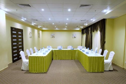 a conference room with a long table and white chairs at Best Western Plus Salmiya in Kuwait