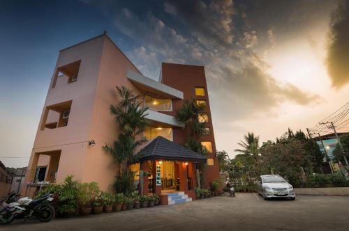ein Gebäude mit einem davor geparkten Auto in der Unterkunft Baansilp Hotel in Chiang Rai